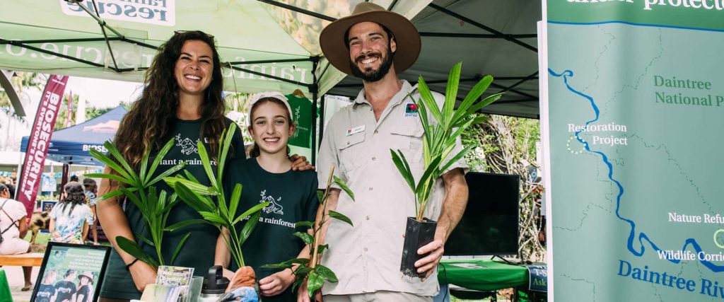 Rainforest Rescue's stall at Cairns Ecofiesta 2024. Milly, Daisy and Martin are at the stall.